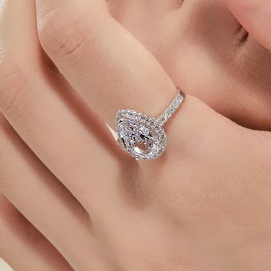 Diamond pear cut ring on a finger with a soft background