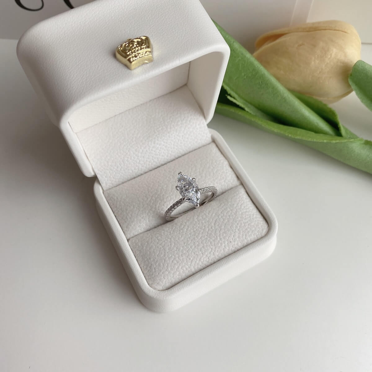 A marquise-shaped Cubic Zirconium ring with smaller stones set in a semi-full pavé band, with a champagne gold finish.